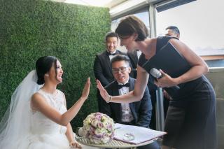 Celebrant Reviews. Celebrant giving high five to bride during signing of the register