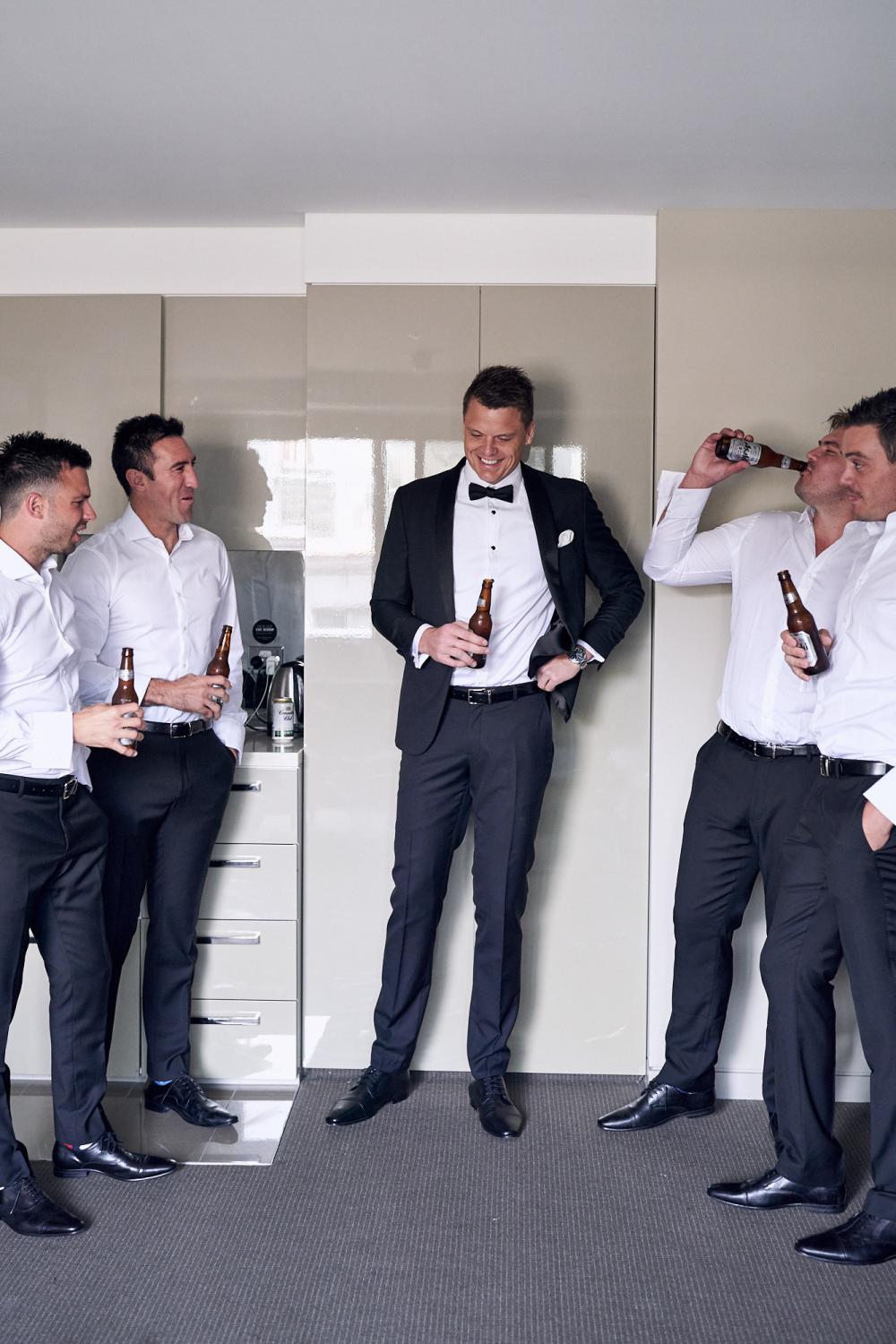 A Groom and his groomsmen enjoying a beer before the wedding together