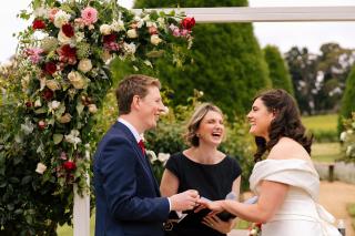 Bride, Groom and celebrant laughing during wedding ceremony