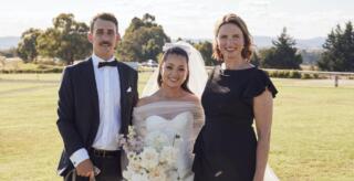 Bride + Groom posing for photo with female marriage celebrant and dog